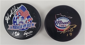 Lot of 2 Mark Johnson & Eric Strobel Autographed 1980 Olympic Hockey Pucks